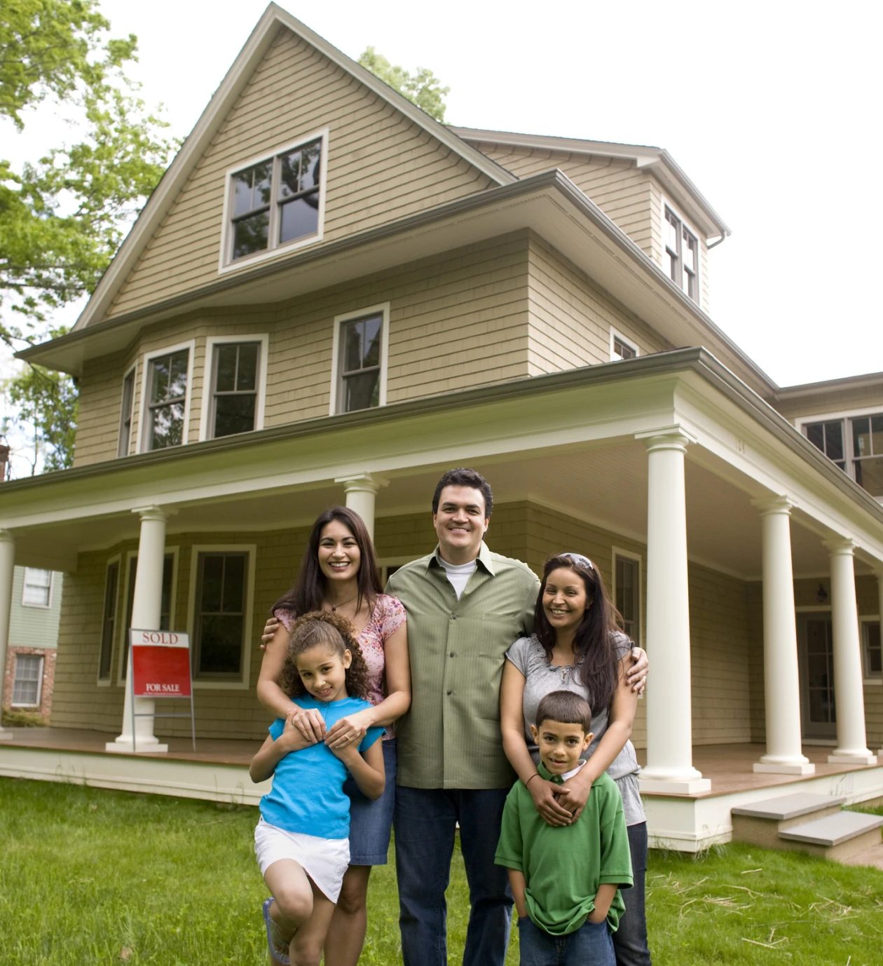 Family smiling in front of new home