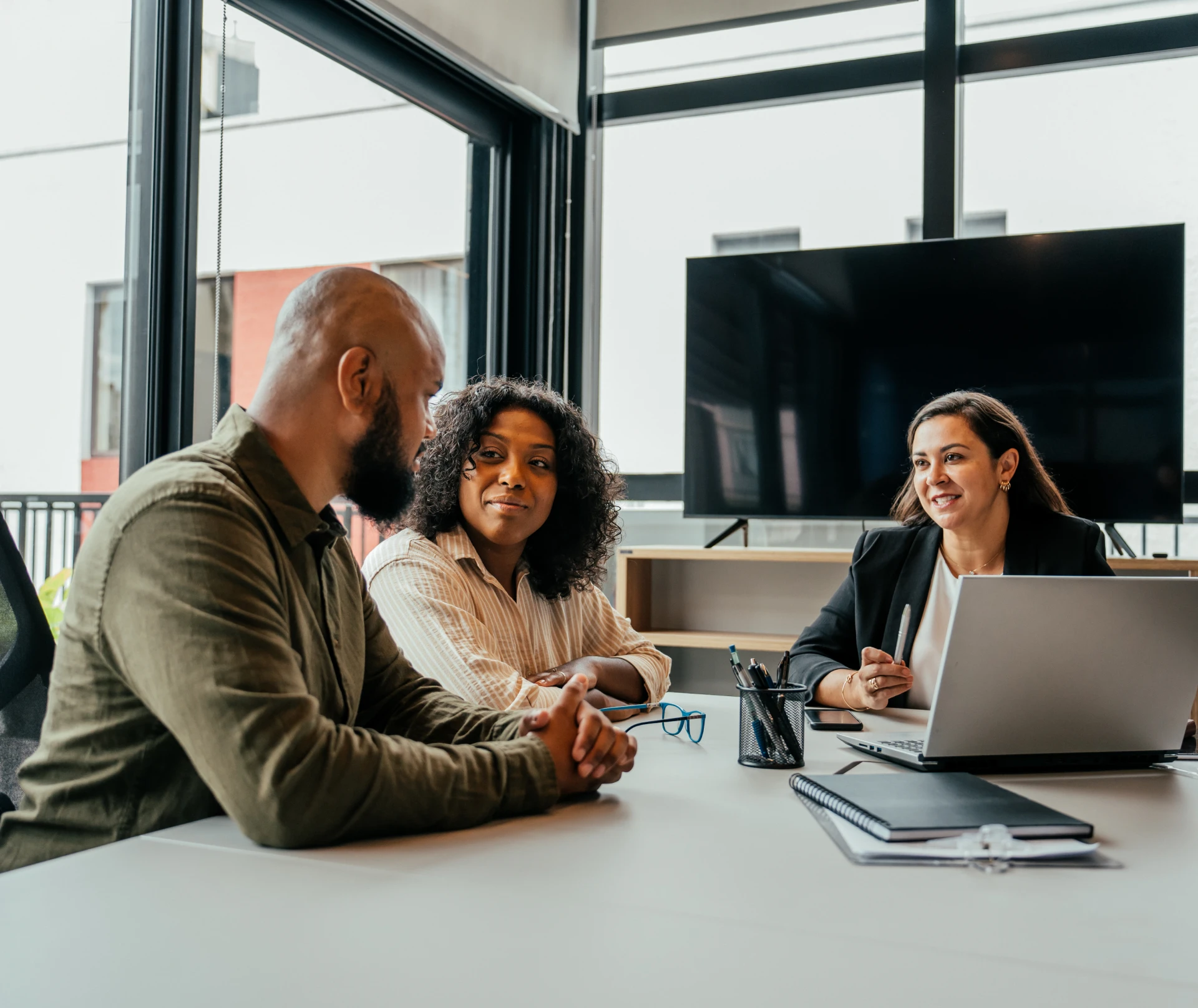 Business meeting with three people discussing